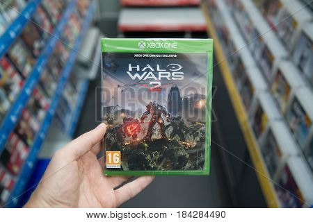 Bratislava, Slovakia, circa april 2017: Man holding Halo Wars 2 videogame on Microsoft XBOX One console in store