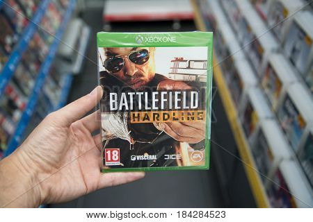 Bratislava, Slovakia, circa april 2017: Man holding Battlefield Hardline videogame on Microsoft XBOX One console in store