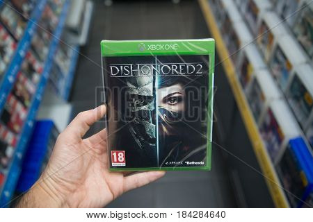 Bratislava, Slovakia, circa april 2017: Man holding Dishonored 2 videogame on Microsoft XBOX One console in store