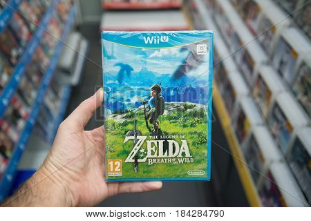 Bratislava, Slovakia, circa april 2017: Man holding The Legend of Zelda: Breath of the wild videogame on Nintendo WiiU console in store