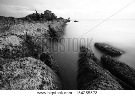 Beautiful Seascape,Ocean & Rocks at Sunset in black & white image.Known as Bonsai lonely tree Layang Layangan & lconic landmark in Labuan island,Malaysia.
