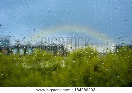 Close-up of Raindrops on a Window. Rain-drops on a Window in front of a Rainbow. Rainy Days. April Weather