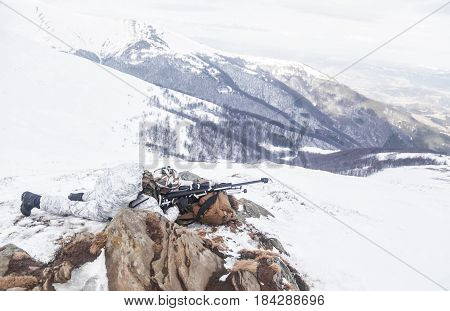 Army soldier with Sniper rifle in action in the Arctic. He lies among the cold rocks and stones, almost freezing to death, but waiting as long as enemies appear to kill them. Duty, service and loyalty