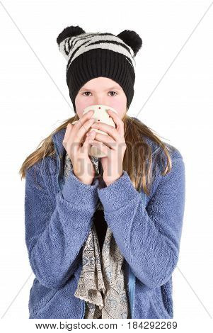 Young girl with jacket and wooly hat holding cup isolated on white background