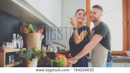 Couple cooking together in their kitchen at home.