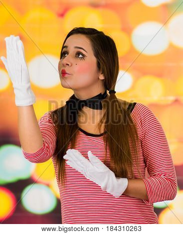 Closeup portrait of cute beautiful young girl clown mime sending kiss