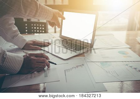Business man and partner pointing at laptop while discussing it