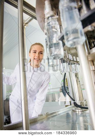 Female worker near conveyour at a water factory