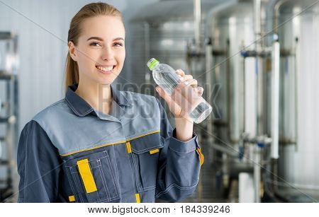 Specialist with bottle of pure water at a water factory