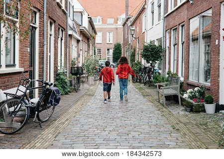 Haarlem Netherlands - August 3 2016: Kids walking in a picturesque street with beautiful traditional houses in Haarlem