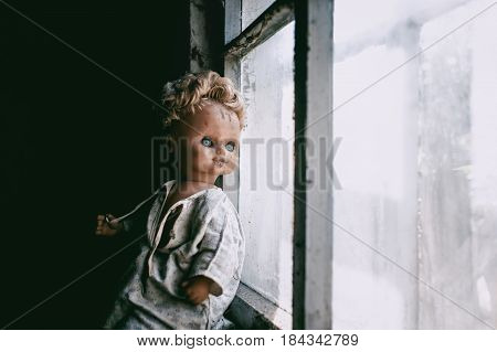 Old doll near the window in day light.