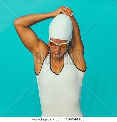 Female swimmer streching on poolside, square image
