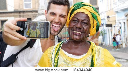 Tourist taking a selfie with a Baiana in the old colonial district of Salvador, Brazil