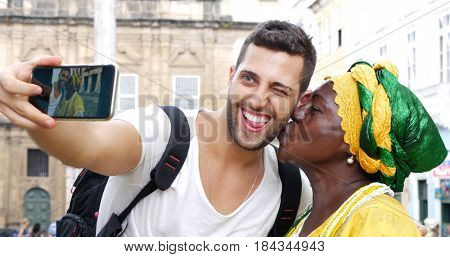Tourist taking a selfie with a Baiana in the old colonial district of Salvador, Brazil