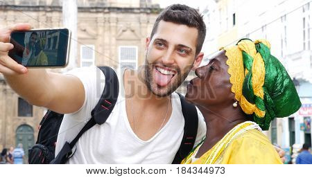 Tourist taking a selfie with a Baiana in the old colonial district of Salvador, Brazil