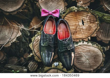 Men's lacquered shoes on a wooden background. Groom's wedding accessories.