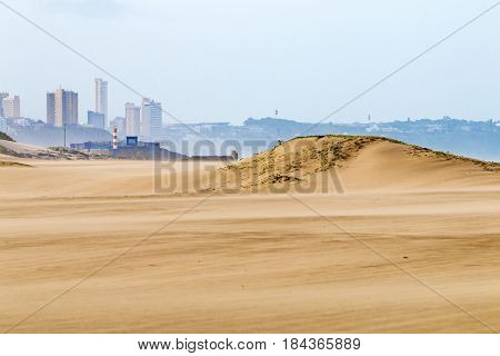 Heavy Wind  Blowing Sand On Beach Against City Skyline