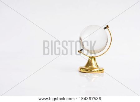 Transparent globe object with gold base on white background