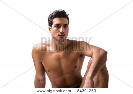A handsome latin young man sitting naked on floor, wearing only underwear. Muscular build