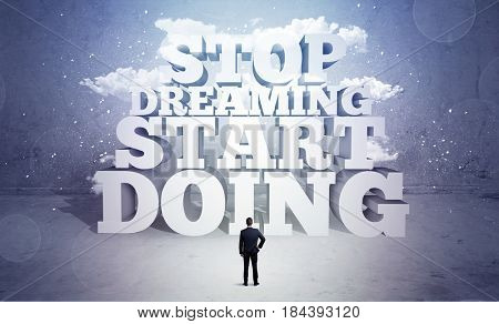 A lazy sales person standing in emty space with huge block letters illustration saying stop dreaming start doing and clouds concept