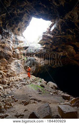 Speleologist performing rope maneuvers in a cave. Zaragoza Province, Aragon, Spain.