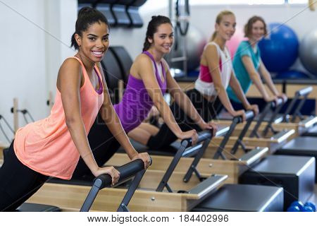 Group of women exercising on reformer in gym