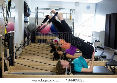 Group of women exercising on reformer in gym