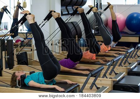 Group of women exercising on reformer in gym