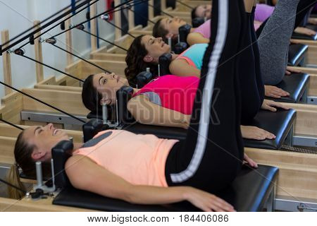 Group of women exercising on reformer in gym