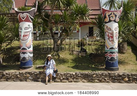 Asian Thai Woman Travelers Visit And Portrait With Phi Ta Khon Statue For Writing Blog At Phi Ta Kho