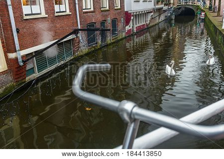 River canal and old street with bicycle parking lot in Dutch Delft old city