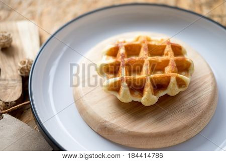 Tasty hot homemade waffles served on wooden plate
