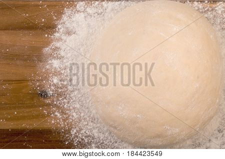 Ball A Dough And White Flour On A Wooden Cutting Board. Top View, Close Up.