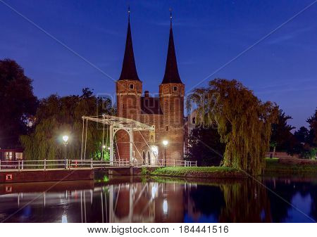 Eastern Gate with the white draw bridge, along Delftse Schie canal at night, Delft, Holland, Netherlands.