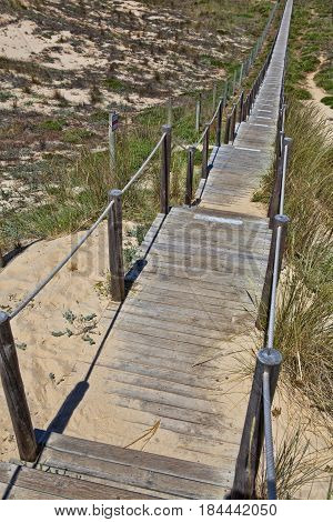 Wooden board path way to the sandy beach