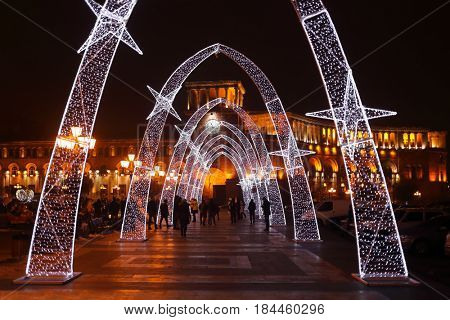 YEREVAN, ARMENIA - JAN 5, 2017: Arcade with illumination at Republic Square, walking people at night