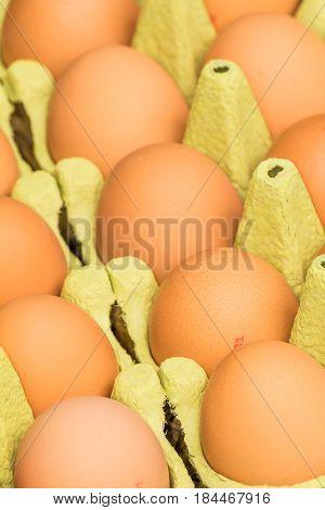 Freerange fresh raw eggs in recycled paper egg cartons or on the straw.