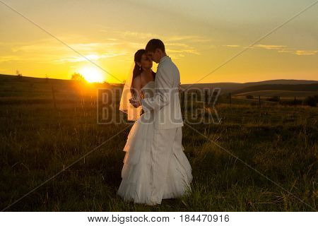 Wedding couple is dansing on the sunset