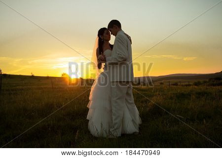 Wedding couple is dansing on the sunset
