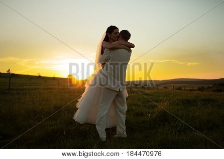Wedding couple is dansing on the sunset
