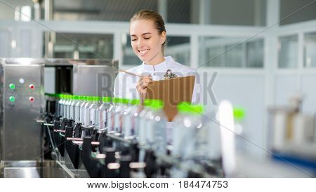 Female worker near conveyour at a water factory