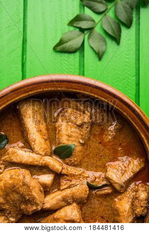 tasty fish curry served with white cooked basmati rice with curry leaves in the background, favourite coastal indian food