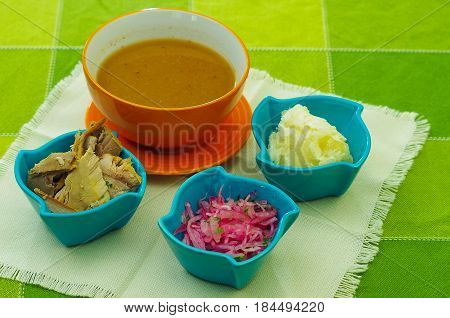 Special mixture of magenta bowls contain, onions, smashed yucca, albacore fish, ready to mix and prepare the encebollado.