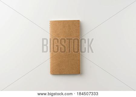 Business concept - Top view of kraft blank notebook on white background desk for mockup