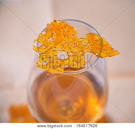 Abstract detail of cannabis oil concentrate aka shatter isolated against white background
