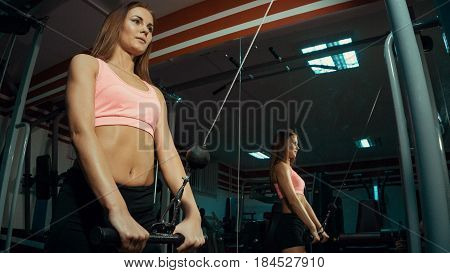 Young beautiful girl doing exercise at the gym.