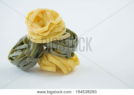 Pile of tagliatelle pasta on white background