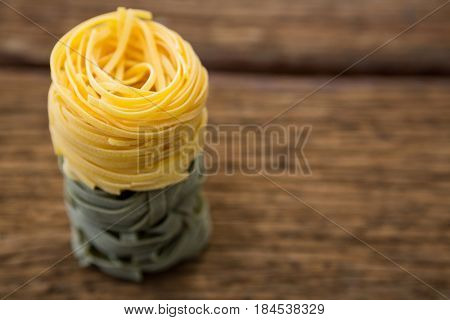 Stack of tagliatelle pasta on wooden surface