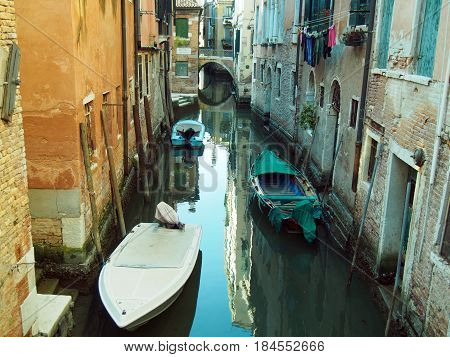 Quiet small canal in venice with bridge and boats