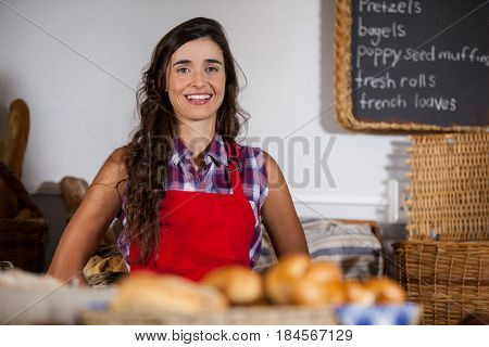 Portrait of female staff standing at bakery section in supermarket